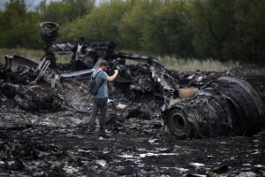 A journalist takes photographs at the site of Thursday's Malaysia Airlines Boeing 777 plane crash near the settlement of Grabovo, in the Donetsk region July 18, 2014. World leaders demanded an international investigation into the shooting down of Malaysia Airlines Flight MH17 with 298 people on board over eastern Ukraine, as Kiev and Moscow blamed each other for a tragedy that stoked tensions between Russia and the West. REUTERS/Maxim Zmeyev (UKRAINE - Tags: POLITICS TRANSPORT DISASTER CIVIL UNREST MEDIA)